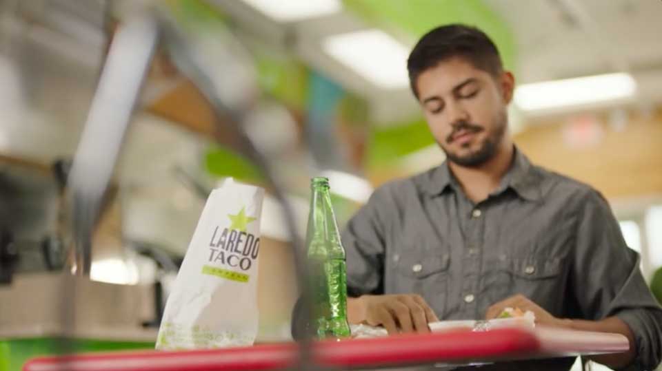 Laredo Taco Company man eating taco